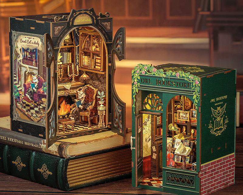 Two intricately designed book-shaped dioramas on a wooden surface. 